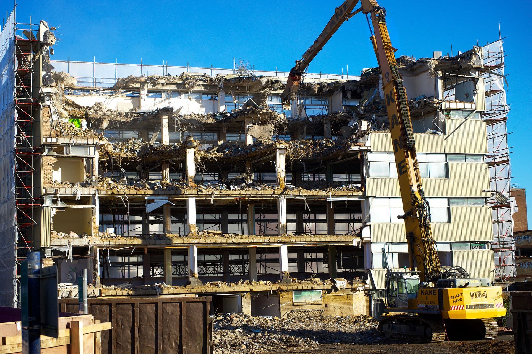 A long-reach excavator taking down a multi-story building floor by floor.